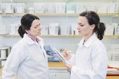 Female scientist discussing plan in laboratory