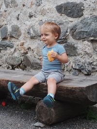 Cute boy sitting on rock