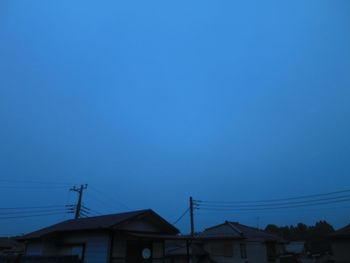 Low angle view of houses against clear blue sky