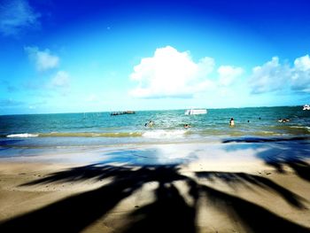 Scenic view of beach against blue sky