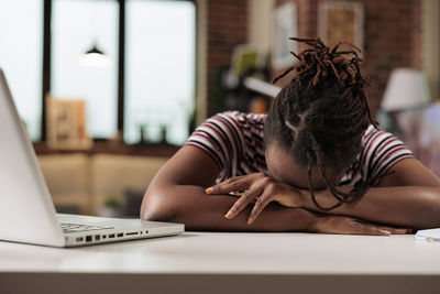 Midsection of woman using laptop at table