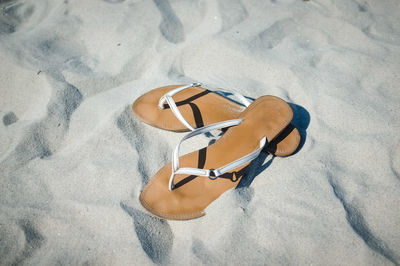 High angle view of flip-flops on sand at beach