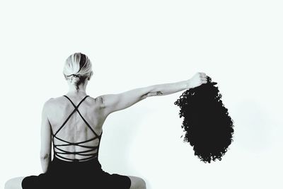 Rear view of woman standing against white background