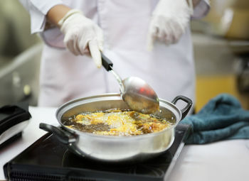 Midsection of man preparing food in kitchen