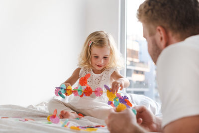 Side view of father and daughter playing with construction 