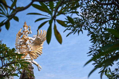 Low angle view of birds on tree against sky