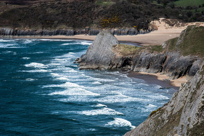 Scenic view of rocky shore by sea