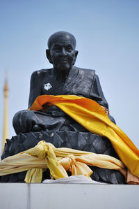 Low angle view of buddha statue against clear sky