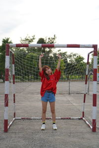 Boy playing soccer on field against sky