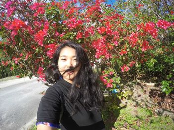 Beautiful young woman with flowers on tree