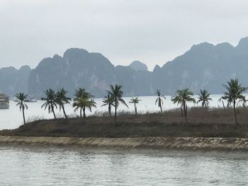 Scenic view of river by mountains against clear sky