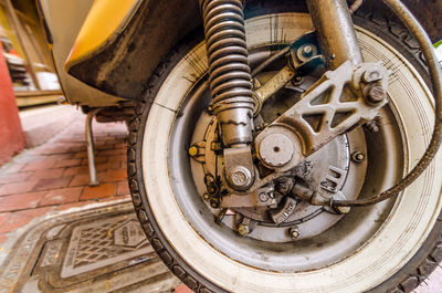 Wheel of old scooter parked by street