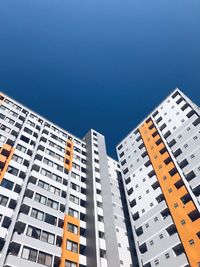 Low angle view of modern buildings against clear blue sky