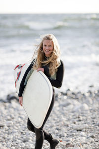 Young woman with surfboard on beach
