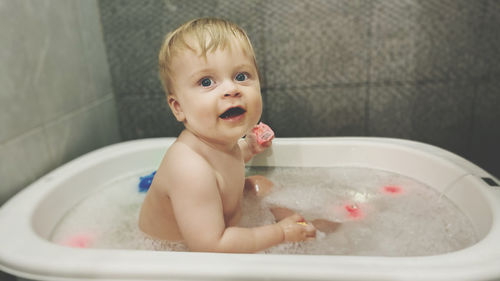 Portrait of cute baby boy in bathroom