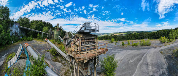 Panoramic view of abandoned car against sky