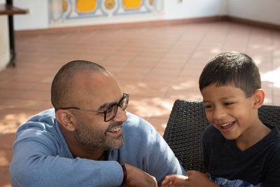 Smiling father and son sitting outdoors