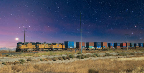 Train on field against sky at night