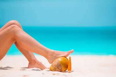 Low section of woman relaxing on beach