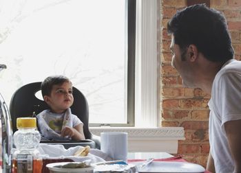 Father and son having breakfast while sitting at home