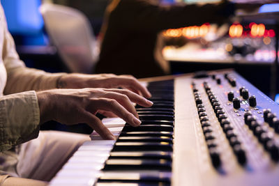 Cropped hands of woman playing piano