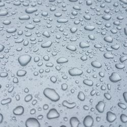 Full frame shot of raindrops on blue glass