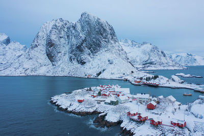 Aerial view of sea by mountains against sky