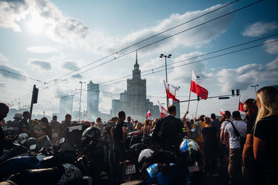 People on street in city against sky