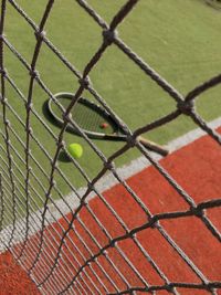 High angle view of tennis balls with racket on grassy field in court