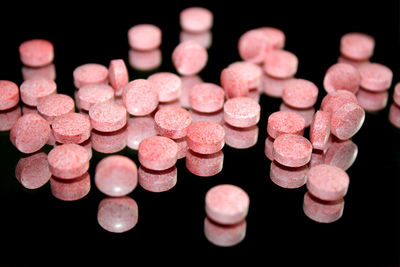 Close-up of pink medicines on black background