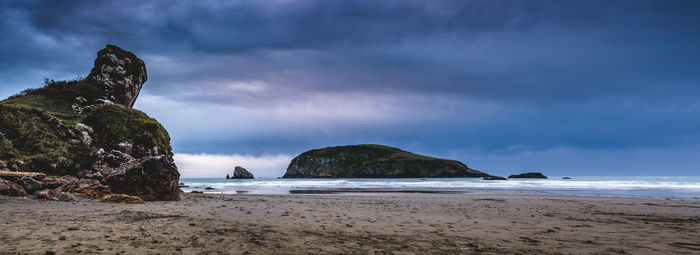 Panoramic view of beach against stormy clouds
