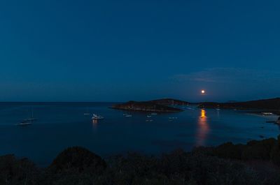 Scenic view of sea against clear blue sky at night