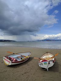 Boat moored on beach against sky