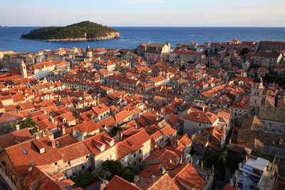 High angle view of houses by sea against sky