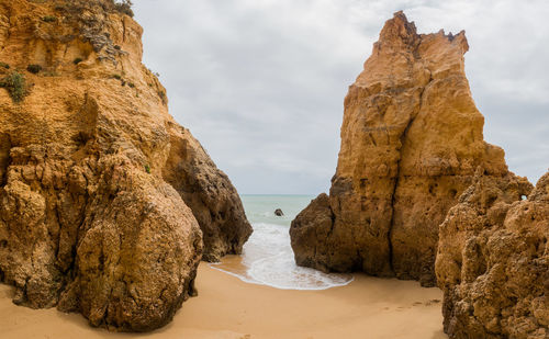 Rocks on beach against sky