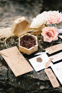 Wedding designer decor and flowers roses, rings and wedding invitations on a stone in nature