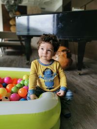 Cute baby boy sitting on ball pool