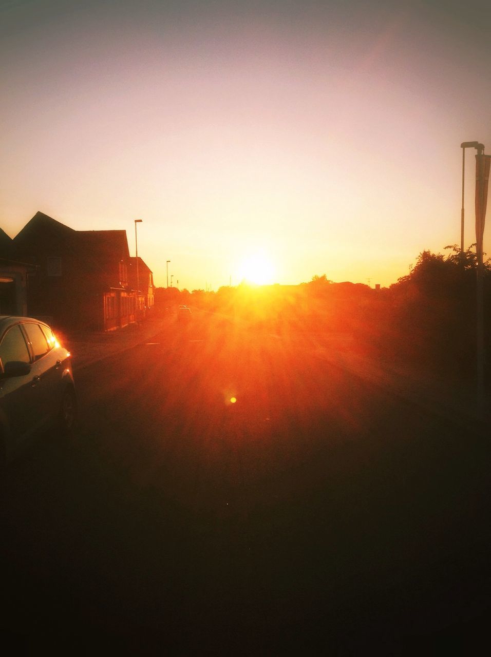 sun, sunset, sunbeam, lens flare, transportation, sunlight, silhouette, clear sky, car, mode of transport, land vehicle, orange color, copy space, building exterior, built structure, architecture, bright, sky, nature, outdoors