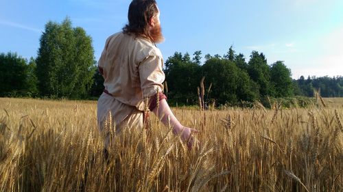 Full length of woman standing on field against sky