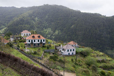 High angle view of houses by trees and mountains