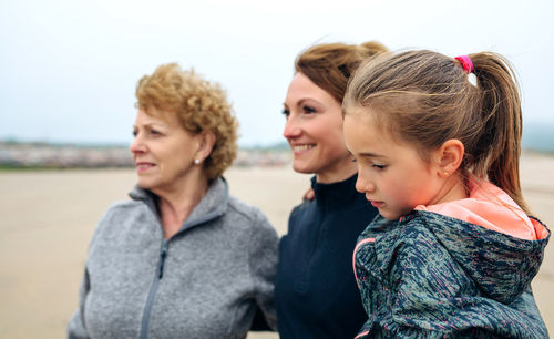 Women and girl walking on beach