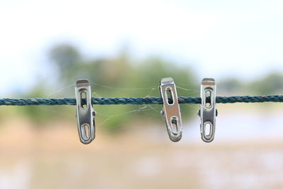 Close-up of metal hanging on rope