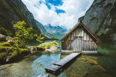 Reflection of shack in lake against sky