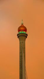 Low angle view of lighthouse against orange sky