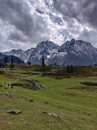 Scenic view of field and mountains against sky