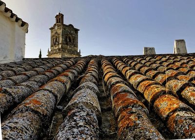 Low angle view of old building roof against sky