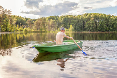 Rear view of man kayaking in lake