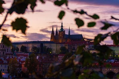 Illuminated cityscape against sky at sunset