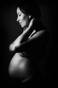 Side view of smiling pregnant woman in darkroom