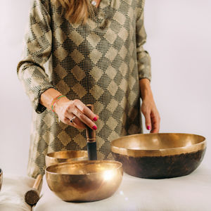 Woman playing tibetan singing bowl in sound healing therapy